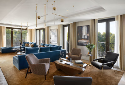 Brown and navy blue formal sitting room with large u shaped sofa and small coffee table area.